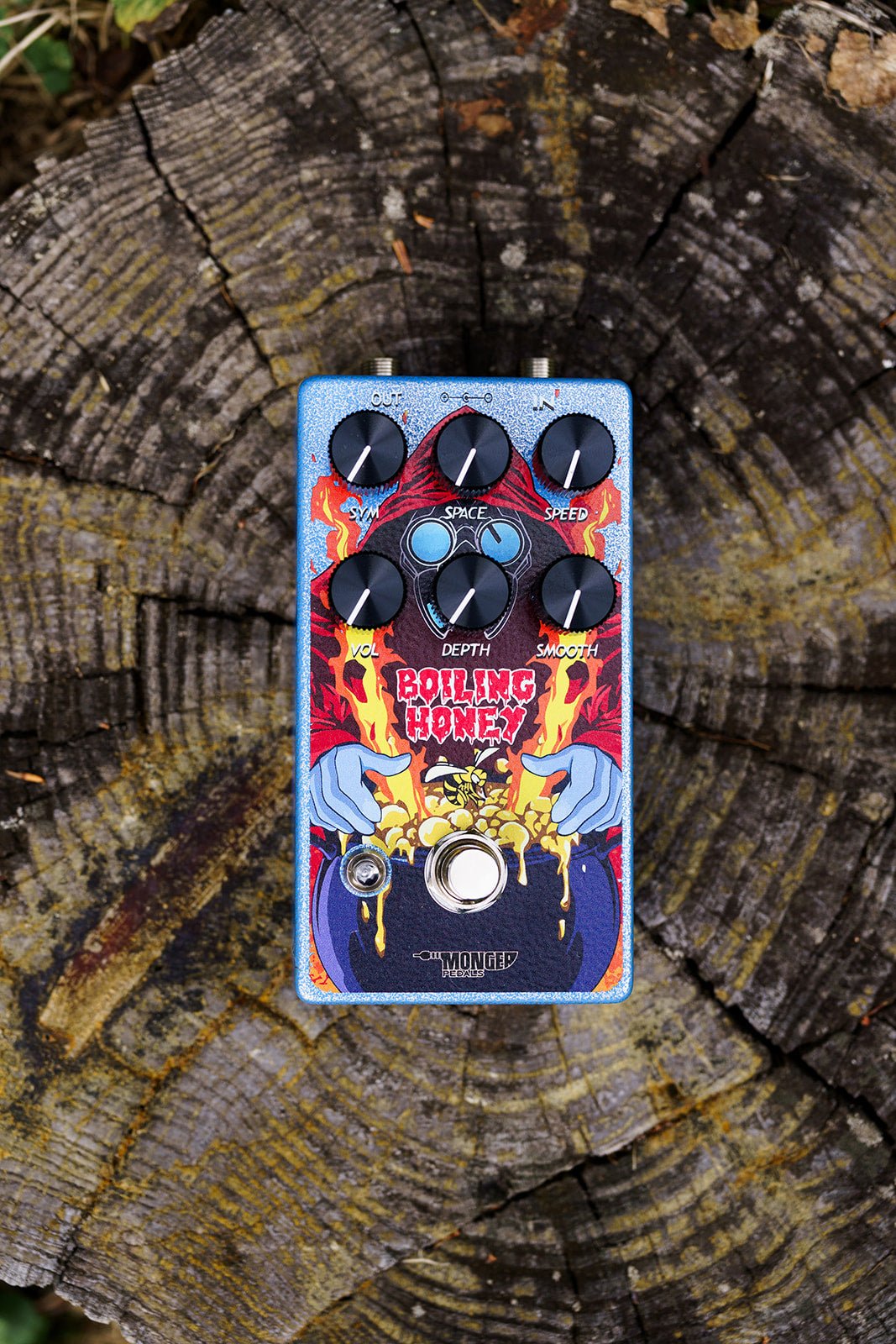 Monger Pedals Boiling Honey Tremolo photographed from above on top of tree stump